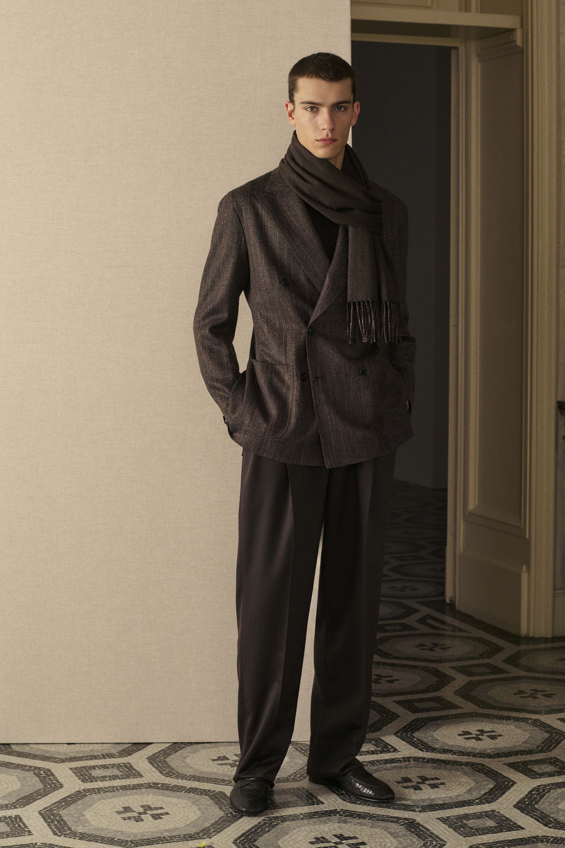 Brioni 26FW 将罗马式裁缝传统带回私密空间：柔光室内、艺术油画背景下，双排扣西装、丝绒感羊毛与精致大衣构建出一种内敛而从容的权力美学。剪裁依然精准，却刻意弱化锋芒，通过柔软肩线与舒适比例回应当代精英对“放松优雅”的渴望。Brioni 不再强调正式场合，而是将高级定制精神融入生活本身，展现真正的老钱式现代性-顽石频道趋势研究
